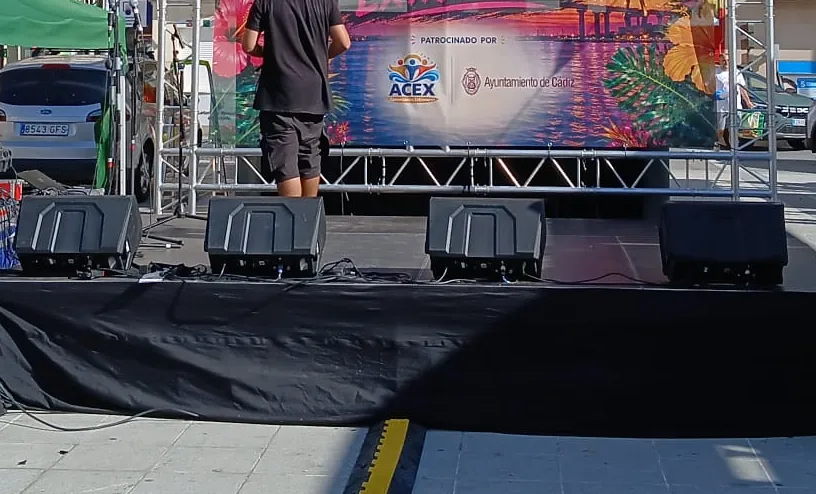 Escenario vestido con faldón negro y monitores colocados
