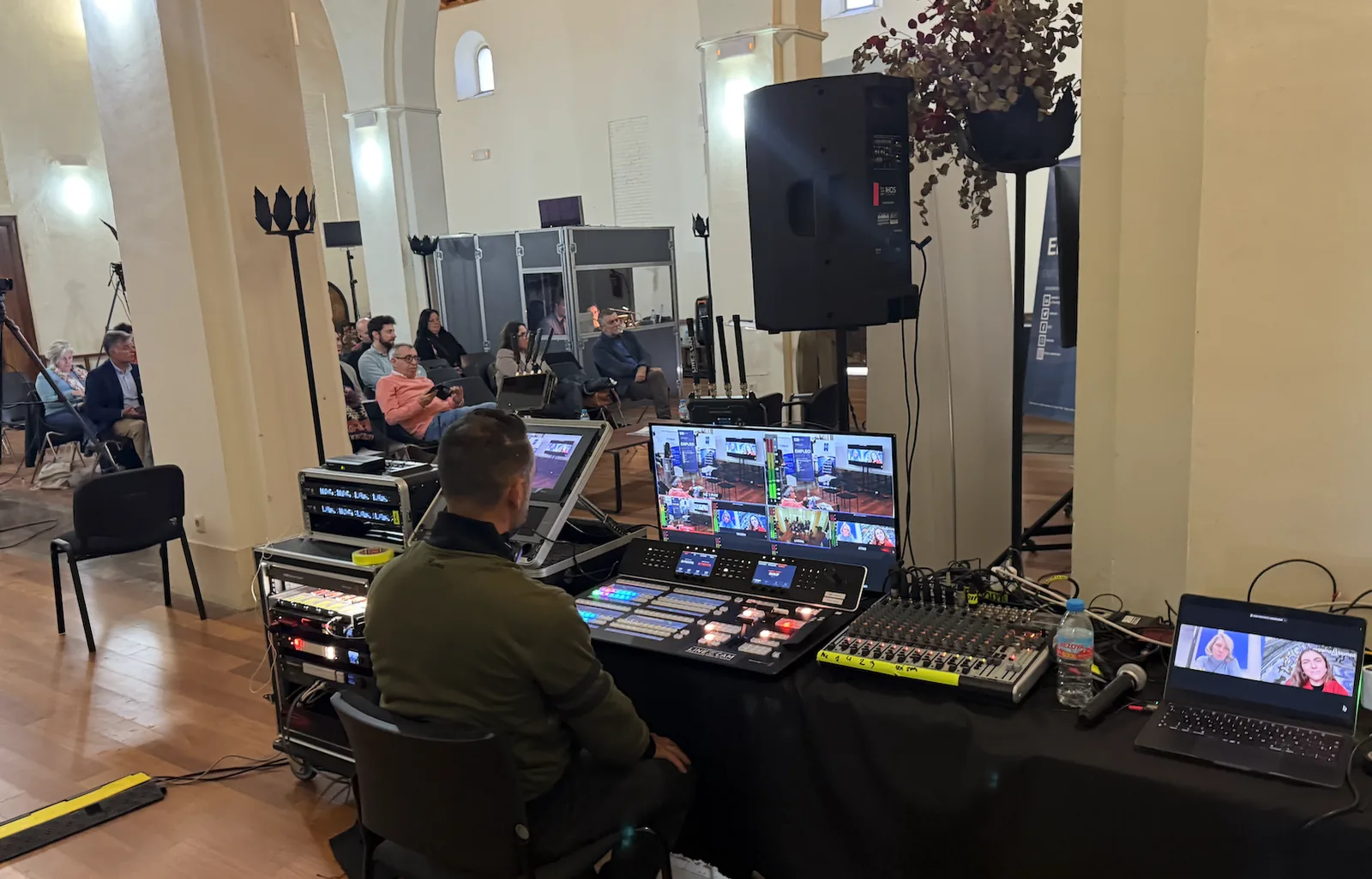 Puesto de control con mesa de vídeo y sonido durante la producción de un evento